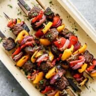 Steak Kebabs stacked on a serving platter.