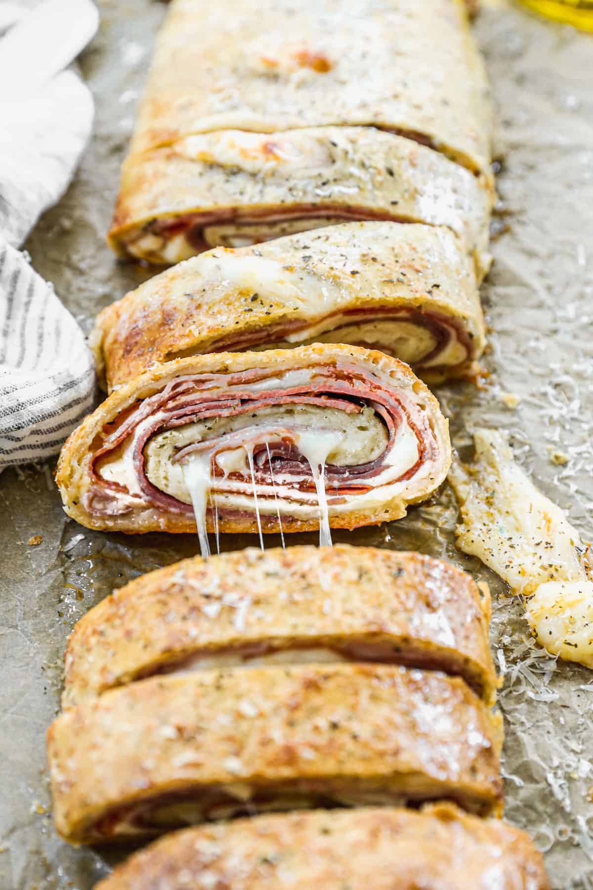 An easy stromboli recipe, sliced to show the layers of mozzarella, ham, salami, provole, and pepperoni.