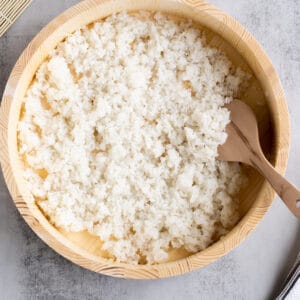 A flat sushi rice bowl filled with perfect sushi rice, ready to be used.