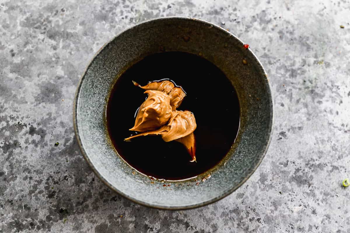 A small bowl with sweet chili sauce, ginger, peanut butter, soy sauce, and crushed red pepper to make a thai lettuce wrap sauce. 