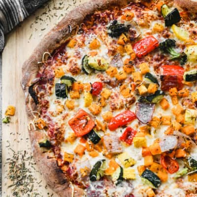 Homemade wheat pizza dough topped with pizza sauce, cheese, and a variety of vegetables.